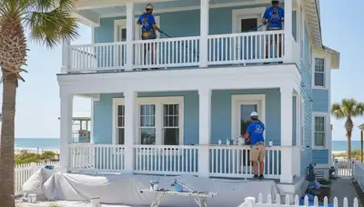Professional painters in Jacksonville, FL applying interior paint for a home service project
